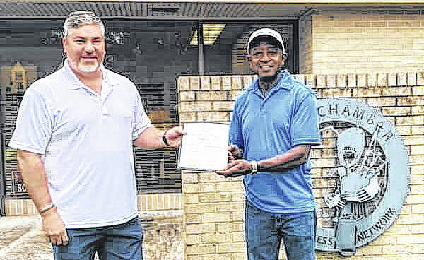 Courtesy photo
Chris English, executive director of the Laurinburg/Scotland County Area Chamber of Commerce, presents Calvin McIntyre with the Governors Volunteer Service Award outside the Chamber offices.