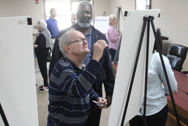 129499506_web1_IMG_8132
Bobbie Singletary places a red dot on a poster of potential photos and concepts of what Hamlet could ideally look like in the future.
Matthew Sasser | Daily Journal