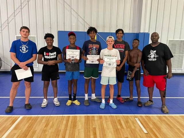 Players and award winners from the Team Unified seventh grade team take a picture with coach Brodie Clark, left, and Andre Reeves, right, during the organizations end-of-the-year awards ceremony and cookout at the Wagram Recreation Center on Sunday.
                                 Contributed by Justin McNickle