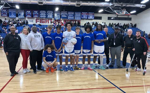 <p>Scotland’s Dylan Lampley (holding basketballs) is recognized before Tuesday’s home game against Southern Lee for reaching 1,000 career points on Jan. 19 at Lee County. Lampley is surrounded by teammates, coaches and administration.</p>
<p>Contributed by Zach McNeil</p>