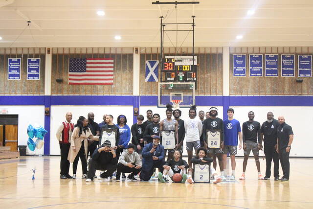 <p>St. Andrews men’s basketball seniors Garrett McRae (holding framed jersey to left), Quwan Barnes (21), Allan Taylor (24) and Karldon Kelley-Williams (2) take a picture with teammates and coaches before Saturday’s game against Union on Harris Court in Laurinburg.</p>
<p>Brandon Hodge | The Laurinburg Exchange</p>