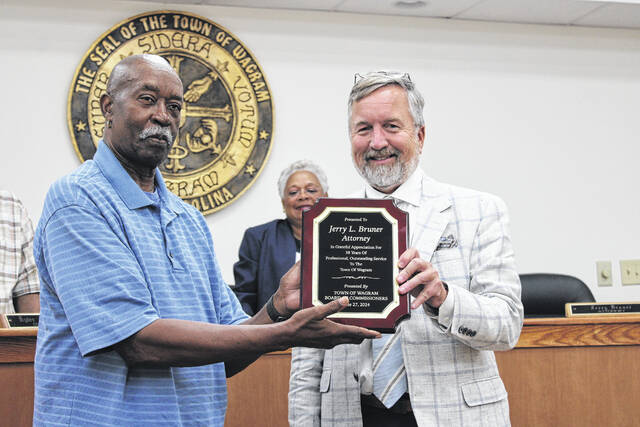 130721756_web1_IMG_2616
The Wagram Board of Commissioners honored the towns longtime attorney Jerry Bruner, who oversaw his last meeting on Thursday. Bruner has been Wagrams attorney for 38 years. Shown is Commissioner Robert McLaughlin, who worked with Bruner for 25 of those 38 years, presenting the attorney with a plaque as fellow commissioners applaud the attorneys years of service.
Tomeka Sinclair | The Laurinburg Exchange