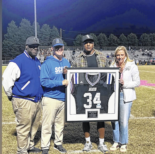 <p>Former Scotland running back Zamir White is honored during halftime with the retirement of his jersey. Shown are athletic director Pat Williams, left, head coach Richard Bailey, Zamir White and Laura Bailey.</p>
                                 <p>Courtesy Photo</p>