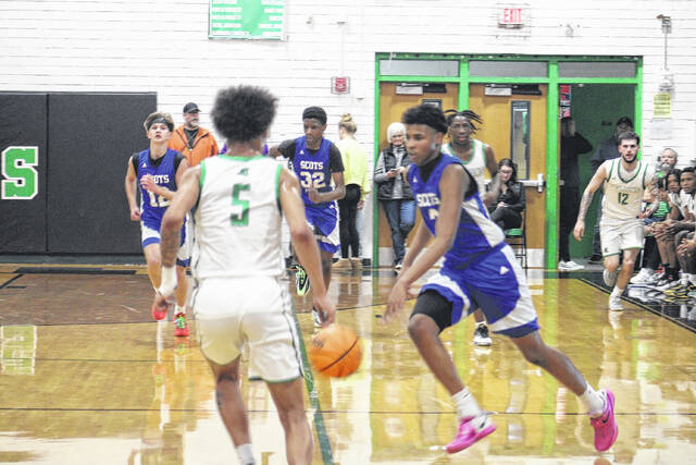 Scotland sophomore Kam Prince (3) drives up the floor in transition against West Brunswick in the first-round playoff game on Feb. 24, 2026. 
                                 Travis Petty Jr | The Laurinburg Exchange