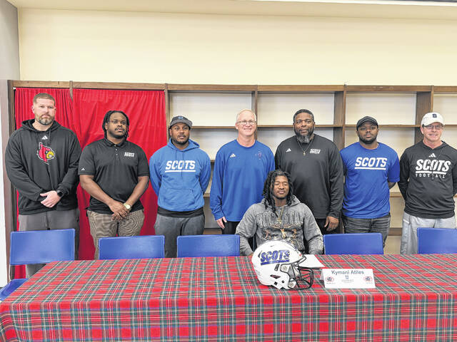 Kymani Atiles, center, is joined by Scotland coaches for his signing day on March 13, 2026. 
                                 Travis Petty Jr | The Laurinburg Exchange