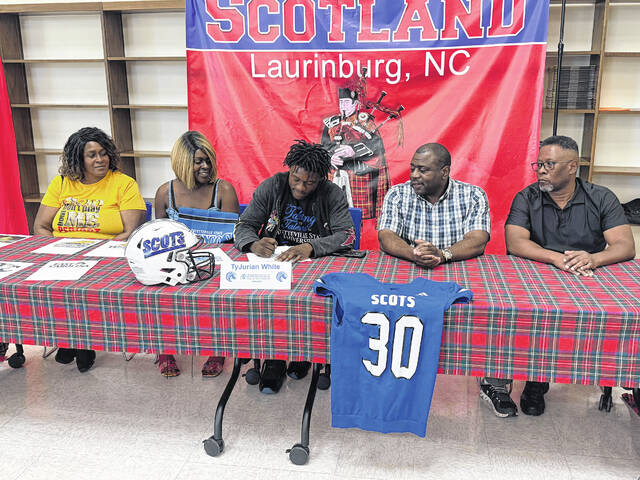 Tyjurian White (center) signs his letter on intent surrounded by family on May 4, 2026.
                                 Courtesy Photos