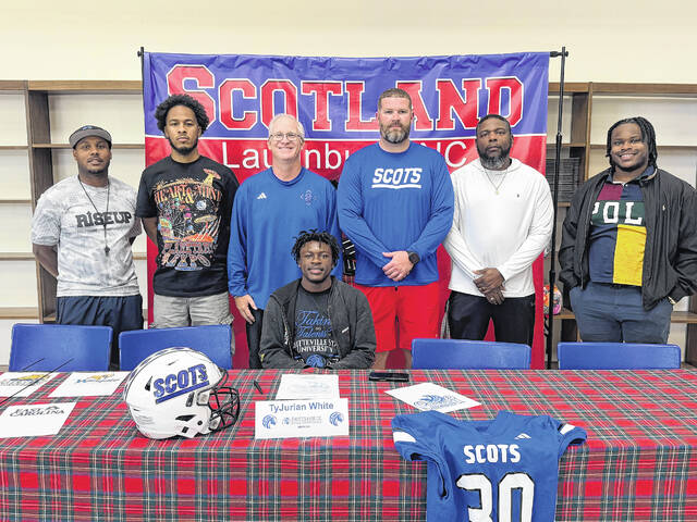 Tyjurian White (center, bottom row) poses with coaches after signing with Fayetteville State on May 4, 2026.
                                 Courtesy Photos
