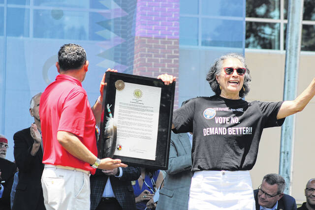 Arlinda Locklear, right, waves to the crowd as she is honored with a resolution by Tribal Speaker Alex Baker, left, during the Lumbee Tribes Federal Recognition Celebration Saturday in Pembroke.
                                 Chris Stiles | The Robesonian