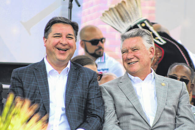 U.S. Reps. David Rouzer, left, and Mark Harris, right, share a laugh during the Lumbee Tribes Federal Recognition Celebration Saturday in Pembroke.
                                 Chris Stiles | The Robesonian