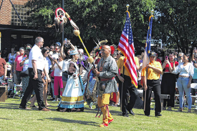 Reggie Brewer, center, leads the grand entry at a powwow during the Lumbee Tribes Federal Recognition Celebration Saturday in Pembroke.
                                 Chris Stiles | The Robesonian