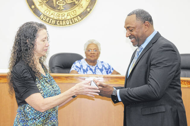 Town Clerk Ann Locklear presents a nameplate to Kendrick Thomas during a special meeting Friday as he was sworn in as Wagram mayor.
Tomeka Sinclair | The Laurinburg Exchange